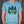 A unisex dusty blue heathered tee with our Woodsy design on the front